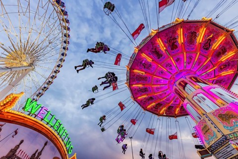 Chain carousel and Ferris wheel in the evening. 177th Cannstatter Volksfest at the Cannstatter
