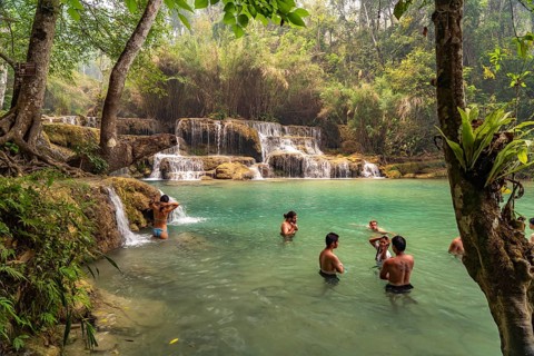 Tourists bathing in the Kuang Si waterfall near Luang Prabang, Laos, Asia