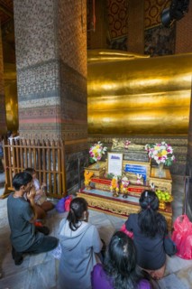 The reclining Buddha with praying believers in Wat Pho temple, Buddhism, religion, world religion,