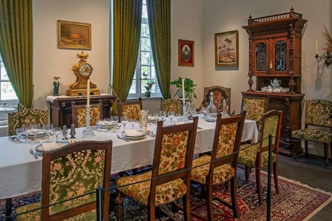 Dinner table with antique tableware in dining room inside 18th century clergy house Schriek at open