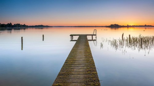 Wooden footbridge at sunrise on Lake Schaalsee, Schaalsee Biosphere Reserve, Zarrentin,