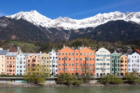 Colourful buildings along the Inn river with snow-covered Nordkette in the background, Karwendel