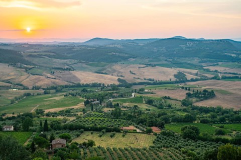 View from Montepulciano into a typical Tuscan landscape in Val d'Orcia with hills, trees, fields,