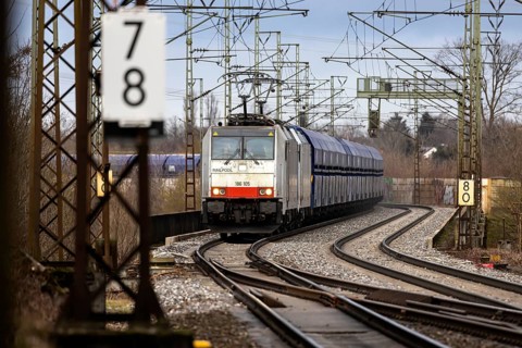 Goods train travelling on the winding Schuster Railway, overhead lines and infrastructure.