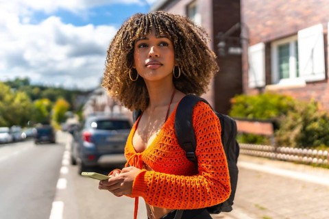 Side view of a beauty young latin woman using the gps of the phone to get directions in the city
