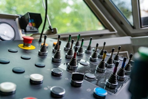 Industrial control panel with levers and various buttons, close-up, track construction Hermann