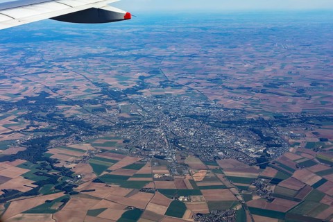 View from an aeroplane over fields and a cityscape, flight, aerial view