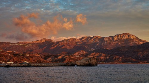 Impressive coastal scene at sunrise with mountains and dramatic clouds in the sky, Pigadia, town