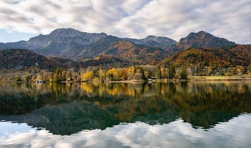 Autumnal mountain landscape with mountain peaks Herzogstand and Heimgarten, reflection in Lake