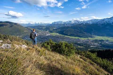 View of Garmisch-Partenkirchen and mountain panorama, mountaineer on hiking trail to Kramerspitz,