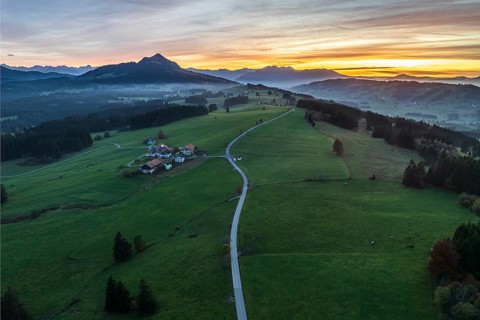 Mountain range near village Wertach, view to mt. Gruenten, sunset, fog in valley, traditional farm,