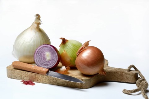 Various onions on wooden board with knife, onion, Allium cepa