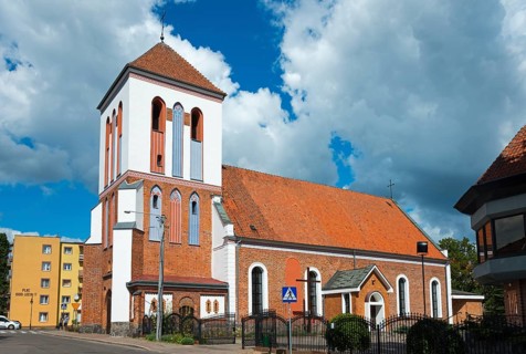 Historic church with brick tower in front of cloudy sky in city neighbourhood, Dominikuskirche,