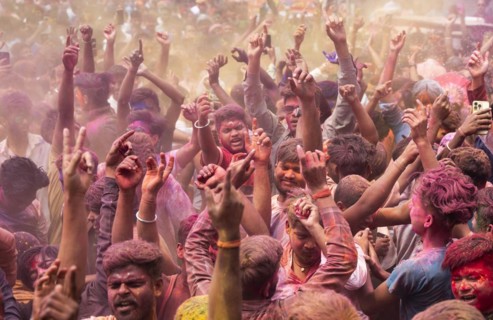 Revellers dancing in the beat of music as they celebrate Holi on a street, the Hindu spring