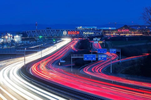 A8 motorway at Stuttgart Airport in the evening. Heavy traffic, lanes of light. Modern architecture