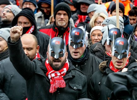 Wearing Batman masks, Volkswagen employees demonstrate in front of the Volkswagen Arena to mark the
