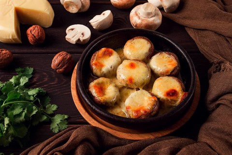 Traditional Georgian dish, appetizer, stuffed mushrooms, Sulguni cheese, baked in a Ketzi clay pan,