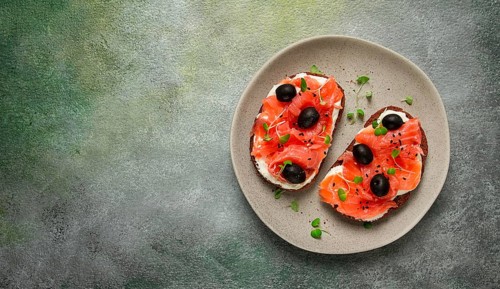 Sandwiches with red fish, cream cheese, olives and microgreens, breakfast