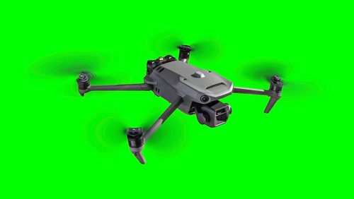 Isolated unmanned aircraft system (UAV) quadcopter drone in the air over A green screen