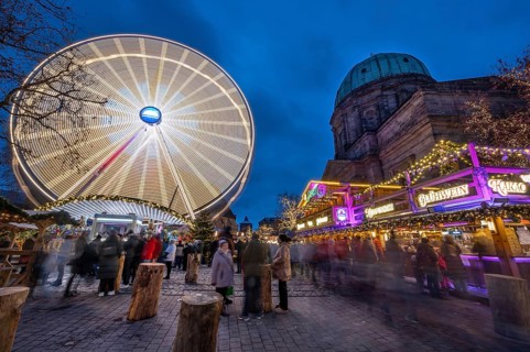 Ferris wheel at the winter village, Christmas market at dusk, St Elisabeth's Church on the right,