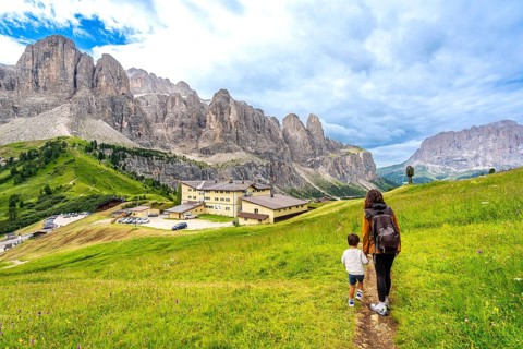 Tourists enjoying a summer hike through the stunning dolomites near gardena pass, italy, surrounded