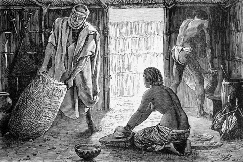 Interior of a hut in the Sahara oasis of Bardaï or Bardai, woman kneeling on the ground and