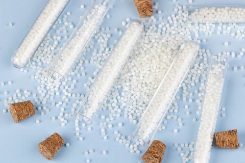Corks and white beads are scattered on a blue surface