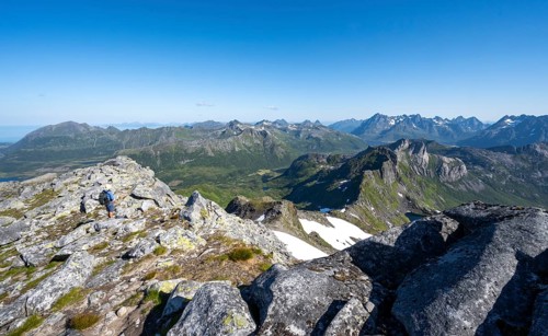 View of mountain landscape, mountain panorama, mountaineer at the summit of Rundfjellet, lake