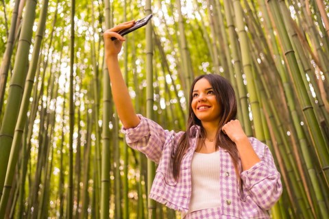 Young caucasian girl with a pink skirt in a bamboo forest. Enjoying summer vacation in a tropical