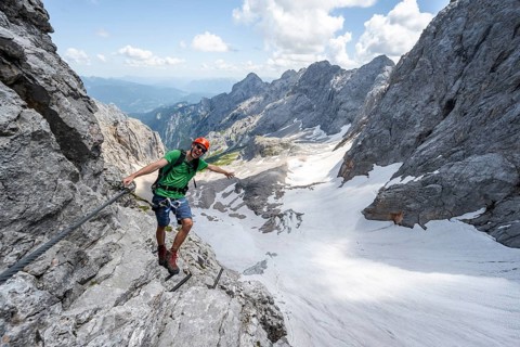 Mountaineer with helmet in a secured via ferrata, Zugspitze via ferrata, ascent to the Zugspitze,