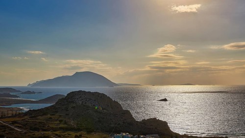 Glittering sea in front of islands in the evening light with dawning sky, Arkasa, west coast,
