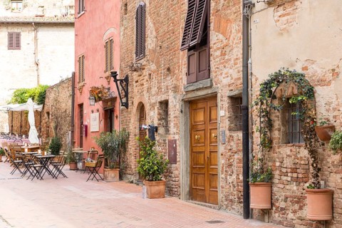 Cosy mix of old houses, shutters and street cafés in the old town of Certaldo, Tuscany, Italy,