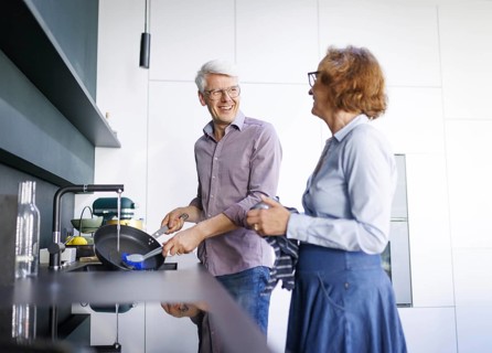 Symbolic photo. An elderly couple stand in the kitchen and do the washing up together. Berlin, 13
