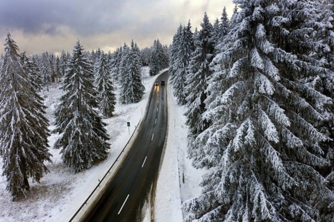 Aerial view, road leads through a snow-covered forest area near Sankt Andreasberg, 14 December 2019