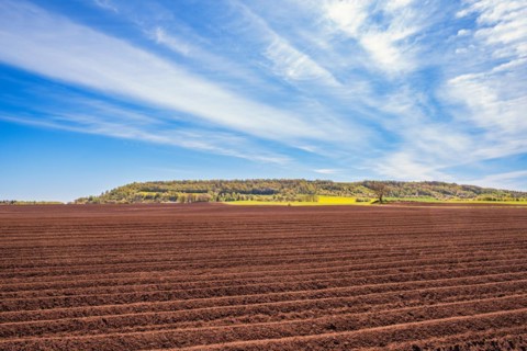 Plowed field in the countryside by a table mountain that is part of the Unesco geopark, Ålleberg,
