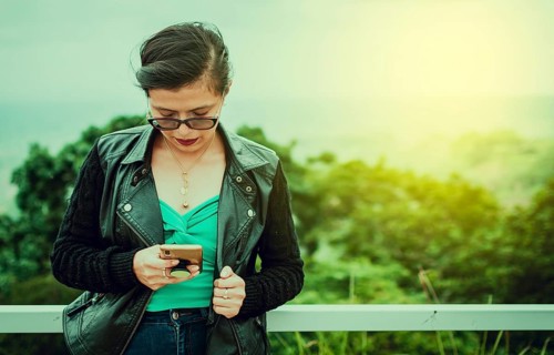 Beautiful urban girl checking and texting phone. Latin woman checking phone outdoors