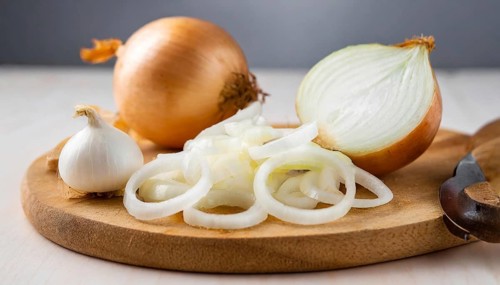 Vegetables, onion, Allium cepa, freshly sliced onion rings and finely chopped onion on a wooden