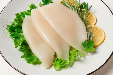Frischer Körper, Tintenfisch, roh, drei Karkassen, Draufsicht, ohne Personen, auf einem Teller