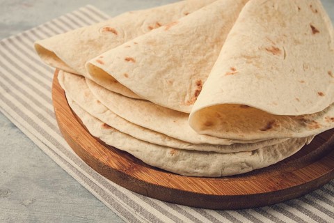 A stack of Mexican tortillas, on a gray table, top view, close-up, no people