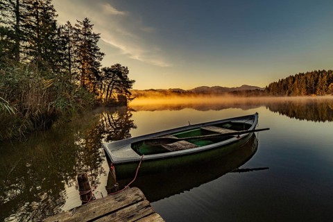 Boats in the autumnal Schmutter Weiher in the Allgäu near the municipalities of Halblech,