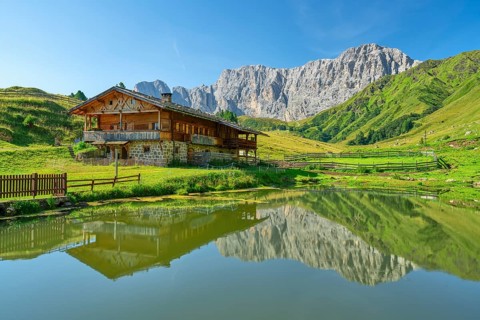 Alpine hut in front of rose garden, reflection, Seiser Alm, Dolomites, South Tyrol