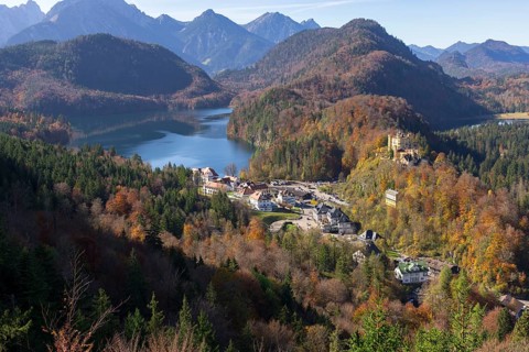 Idyllic valley with autumn-coloured forest, enchanting mountains and a tranquil lake, Schwansee,