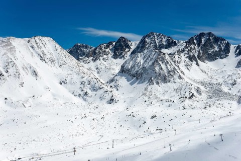 Schneebedeckte Berggipfel unter klarem Himmel in den winterlichen Bergen von Andorra, Skigebiet,