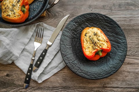 Close-up view of roasted bell peppers stuffed with goat cheese and mozzarella on wooden table