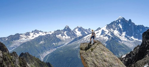 Mountaineer standing on a rock, mountain landscape with mountain peak Aiguille Verte, Mont Blanc