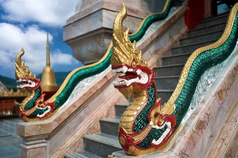 Dragon on staircase of tower with top of Chedi highest building in temple complex buddhist