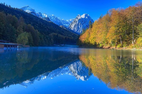 Mountains reflected in lake, fog, morning light, autumn colours, Riessersee, Waxensteine behind,