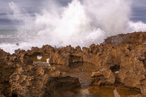 The rocks are scattered throughout the area, with some of them being large and jagged. The water