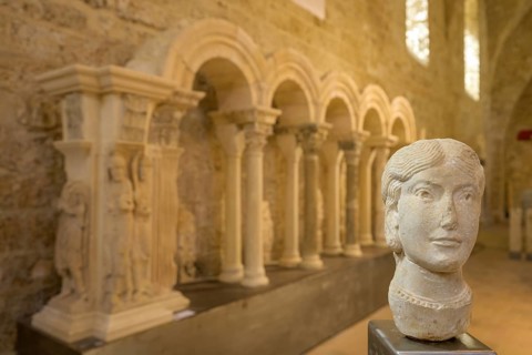 Stone female head in the museum at Gellone Abbey, also Saint-Guilhem-le-Désert Monastery,