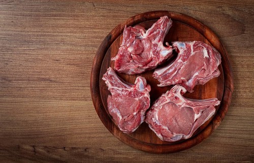 Raw calf meat, meat on the bone, meat for barbecue, cutting board, top view